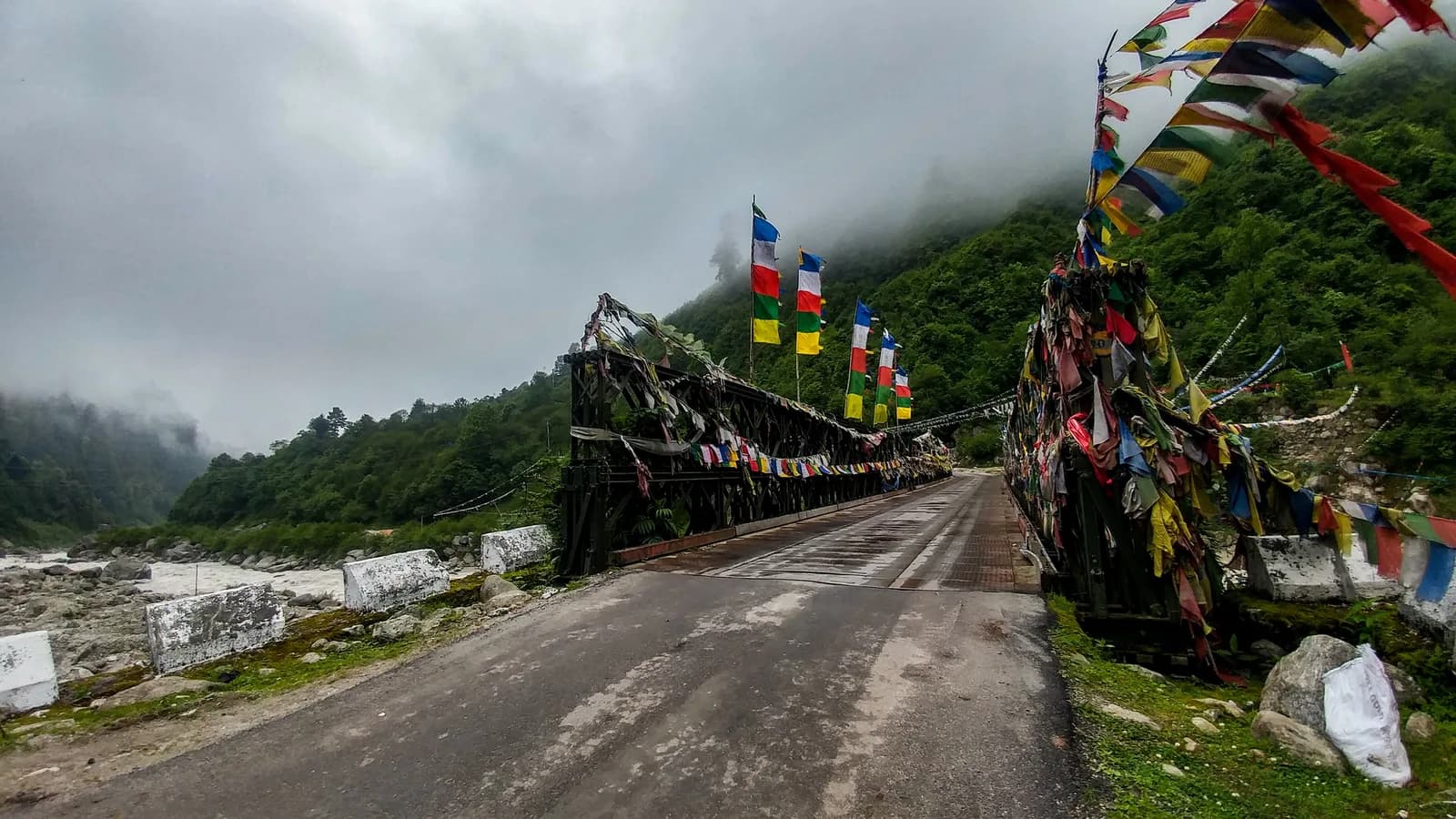 Old bridge with prayer flags on the road to Gurudongmar